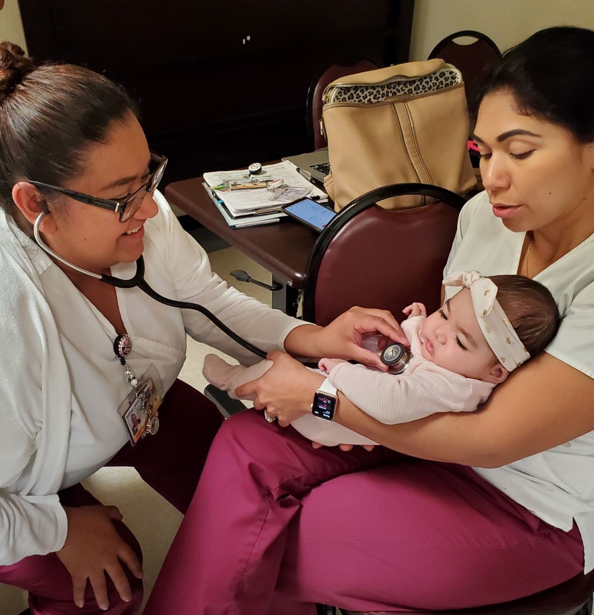 Vocational Nursing students use a stethoscope on an infant
