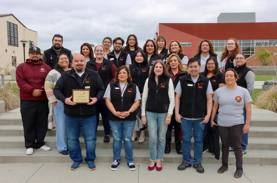 Group of employees standing together holding a plaque