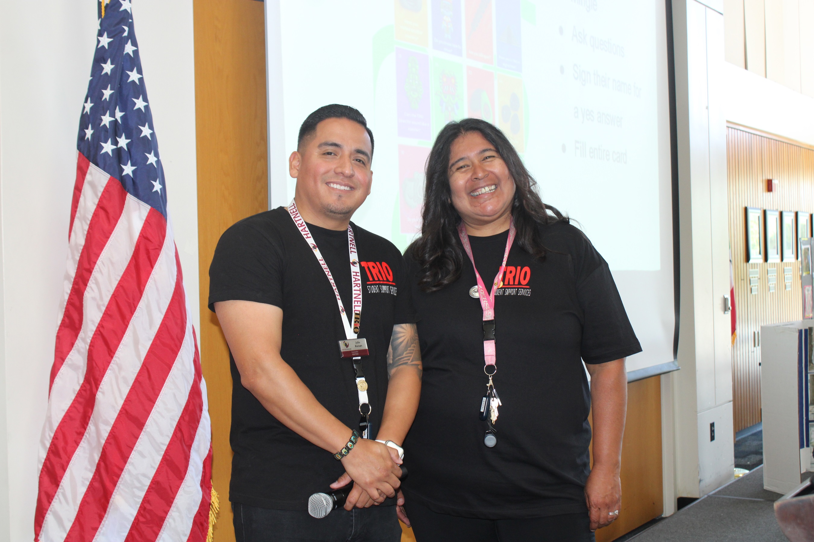 two counselors standing next to each other smiling with their arms crossed